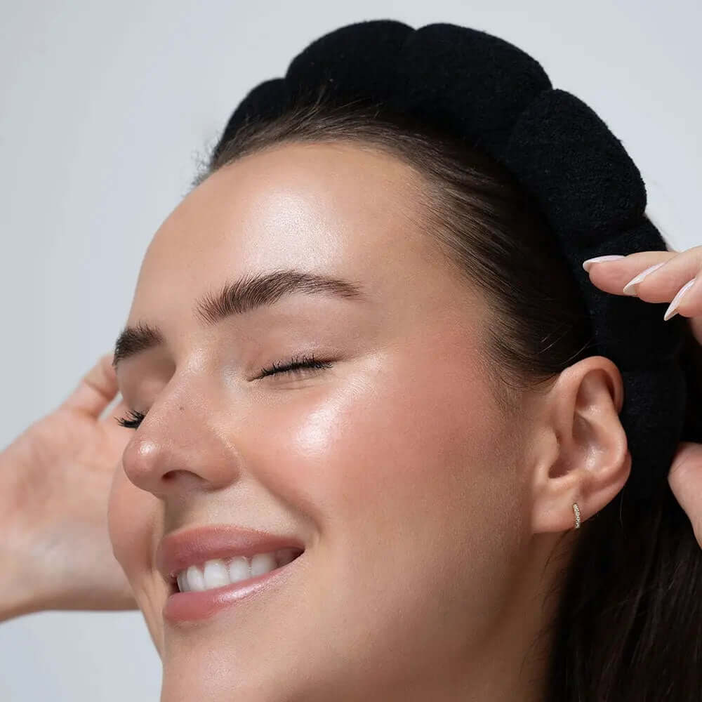 Woman smiling while wearing a Brushworks Black Cloud Headband, featuring a bubble design in soft terry cloth.