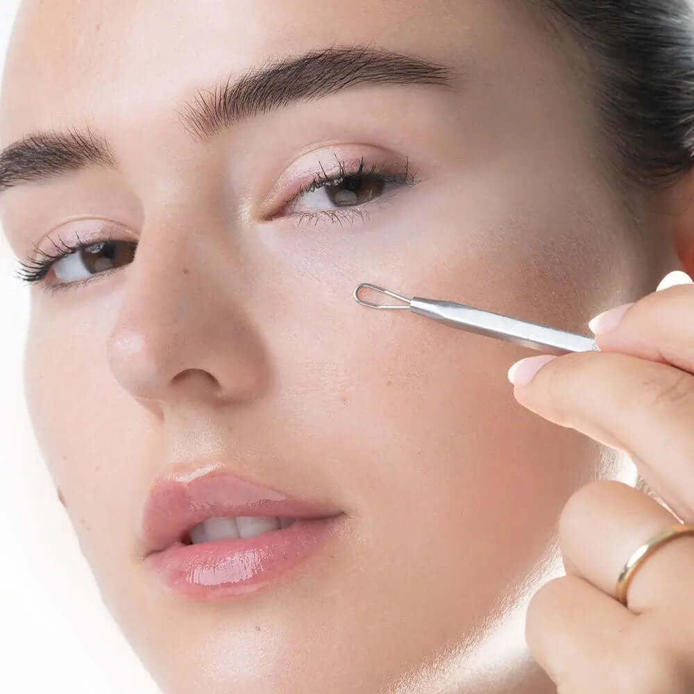 Woman using Brushworks Blackhead and Blemish Remover, highlighting the stainless steel tool on her skin.