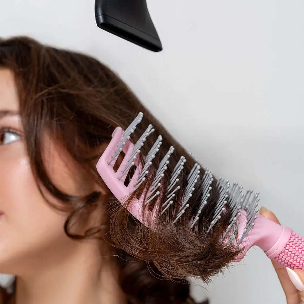 Brushworks Blow Dry Paddle Brush in use, providing a salon-quality blow-dry on curly hair with a hairdryer.