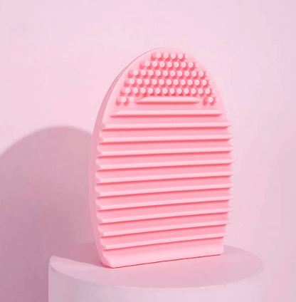 Brushworks Brush Cleaner Tool in pink for deep cleaning makeup brushes, featuring textured surface for effective dirt removal.