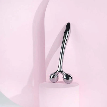 Brushworks Face Sculpting Zinc Roller on a pink background, perfect for facial massage and skin toning.