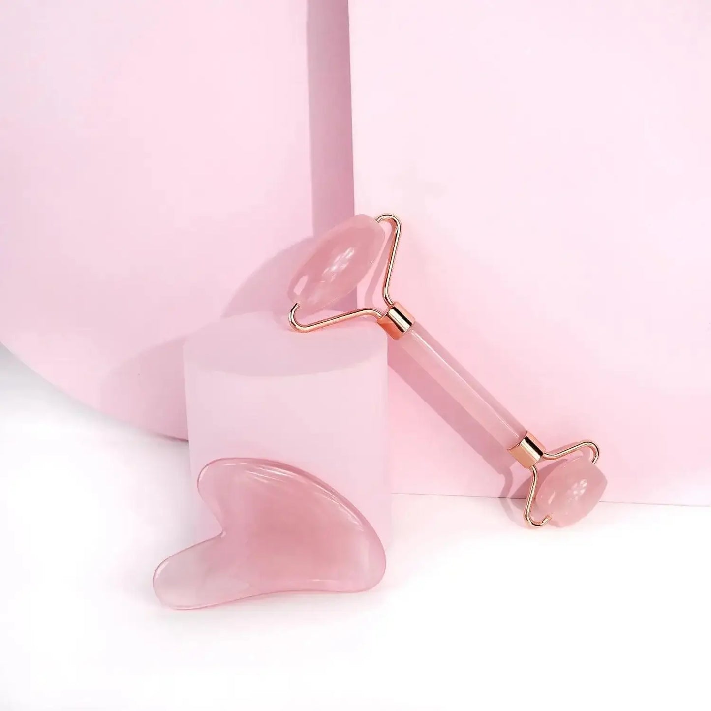 Brushworks HD Rose Quartz Roller and Gua Sha set against a pastel pink background for skincare and facial massage.
