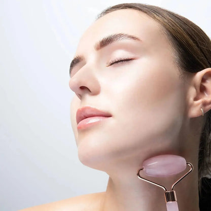 Woman using Brushworks HD Rose Quartz Resin Roller for facial massage to reduce puffiness and enhance skin radiance.
