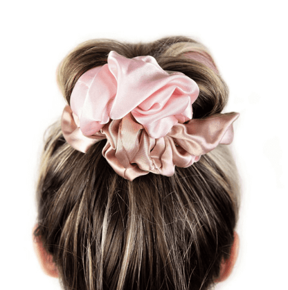 Brushworks Heatless Curling Scrunchie in pink satin, styled in a hair bun for heat-free curls and smooth finish.