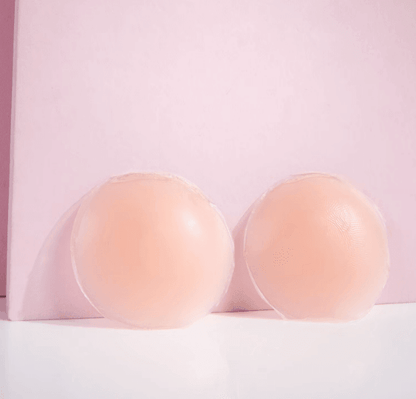 Brushworks silicone nipple covers shown on a pink background, smooth and discreet for braless wear.