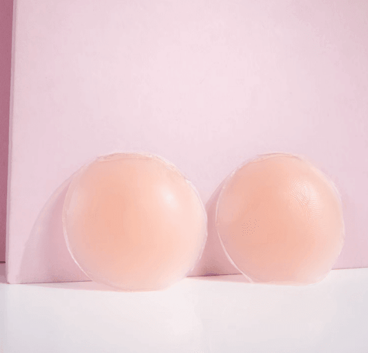 Brushworks silicone nipple covers shown on a pink background, smooth and discreet for braless wear.