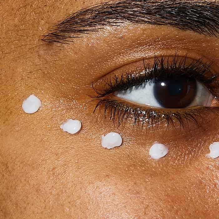 Close-up of CeraVe Skin Renewing Eye Cream being applied in dots under the eye to target dark circles and puffiness