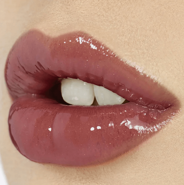 Glossy lips with Charlotte Tilbury Lip Lustre in Pillow Talk, showcasing a nude-pink shade and high-shine finish.