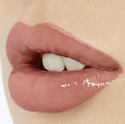 Close-up of lips wearing Charlotte Tilbury Lip Lustre in Pillow Talk, showcasing a glossy nude-pink finish.