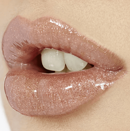 Close-up of glossy lips wearing Charlotte Tilbury Lip Lustre in Pillow Talk, showcasing a nude-pink, shiny finish.