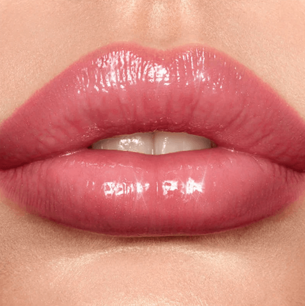 Close-up of glossy pink lips wearing Charlotte Tilbury Lip Lustre for a radiant, high-shine finish.
