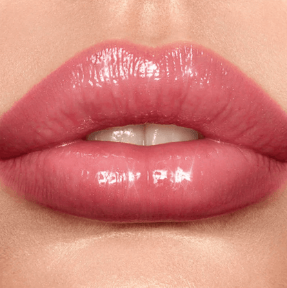 Close-up of glossy pink lips wearing Charlotte Tilbury Lip Lustre for a radiant, high-shine finish.