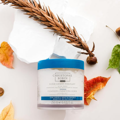 Jar of Christophe Robin hair care product with autumn leaves and a wheat stalk on a white background