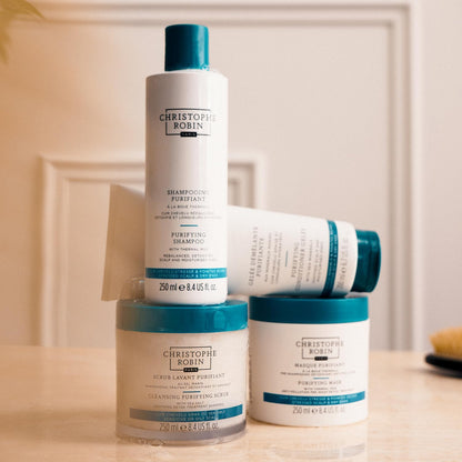 Collection of Christophe Robin hair care products on a wooden surface with a neutral background.