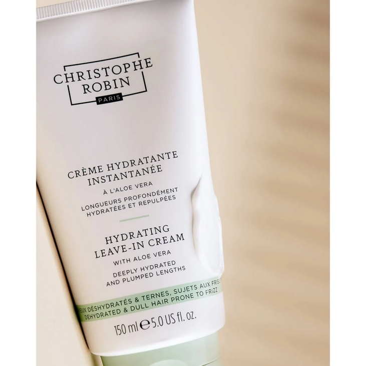 Tube of Christophe Robin hydrating leave-in cream on a beige background