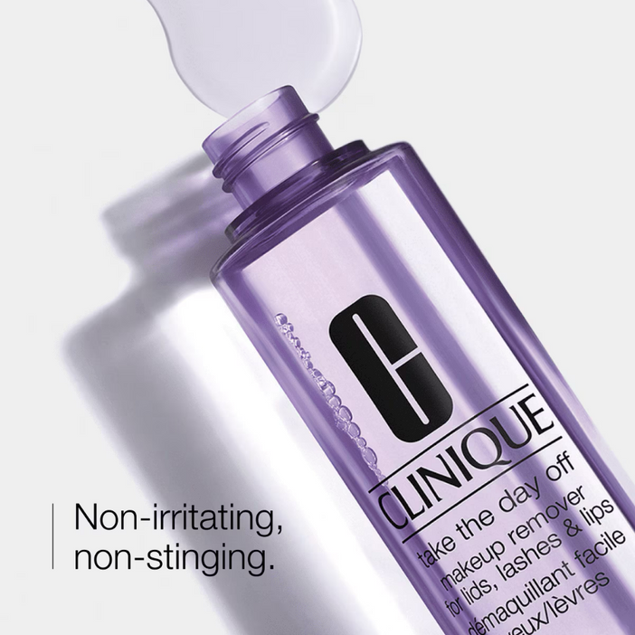 Clinique makeup remover bottle with purple cap on a white background