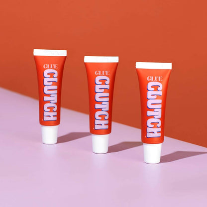CLUTCH Glue Liquid Fashion Tape 15ml tubes on a pink and orange background, perfect for secure fashion solutions.
