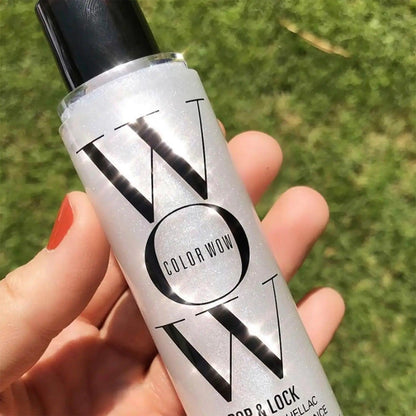 COLOR Wow Pop & Lock High Gloss Finish spray in hand, showcasing its travel-size design and shimmering formula.