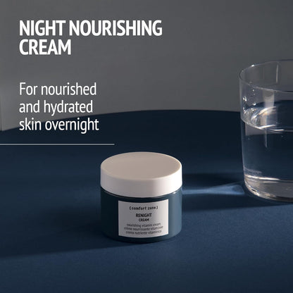 Jar of night nourishing cream with a glass of water on a dark surface