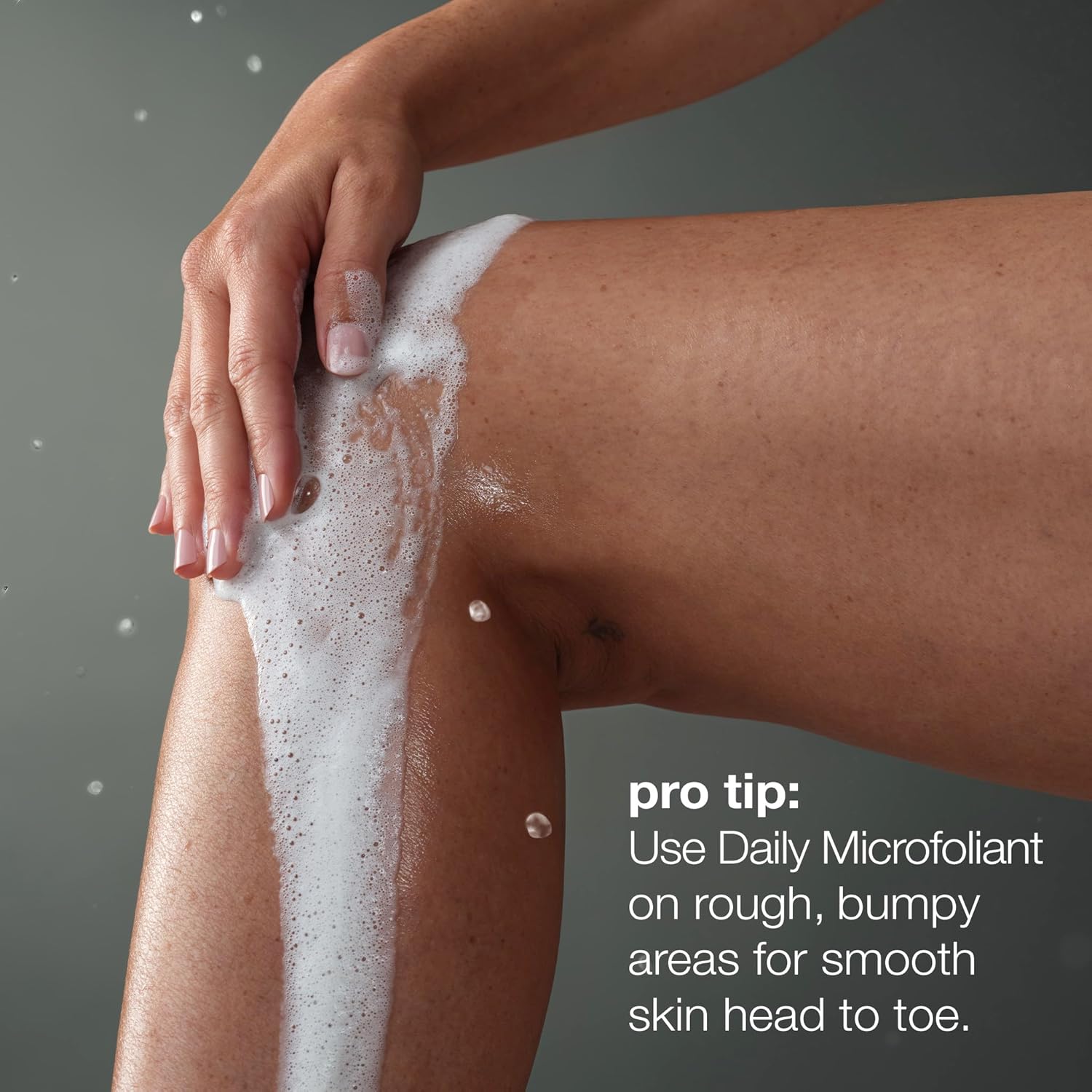 Person applying a foamy Dermalogica product to their leg with a gray background