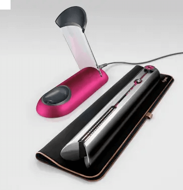 Dyson Corrale Straightener in Nickel and Fuchsia with charging dock and travel case on a neutral background.
