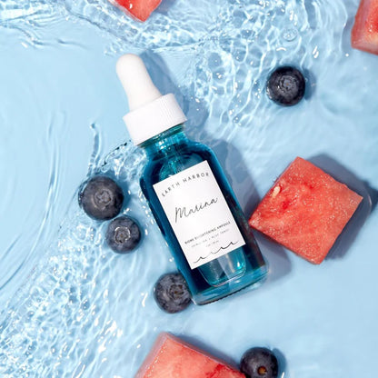 Blue serum Earth Harbor bottle with dropper on a blue background with watermelon and blueberries