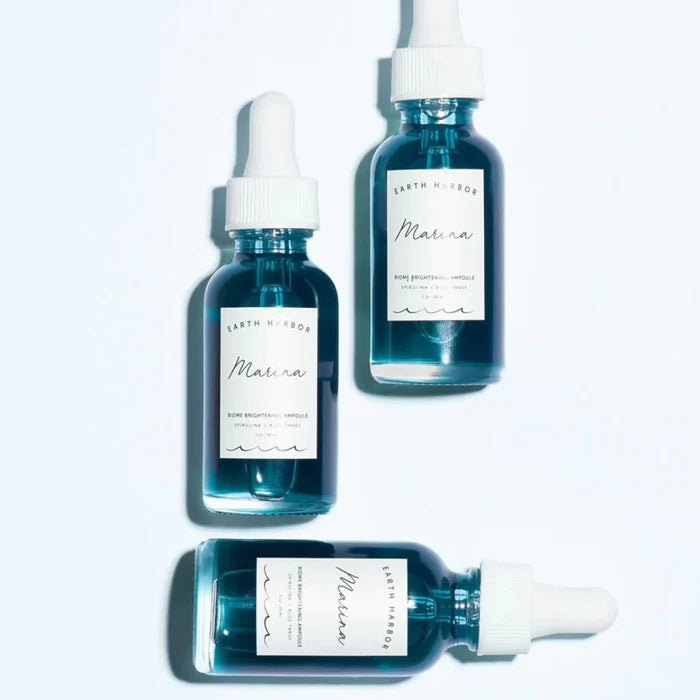 Three blue Earth Harbor bottles with white labels on a light gray background