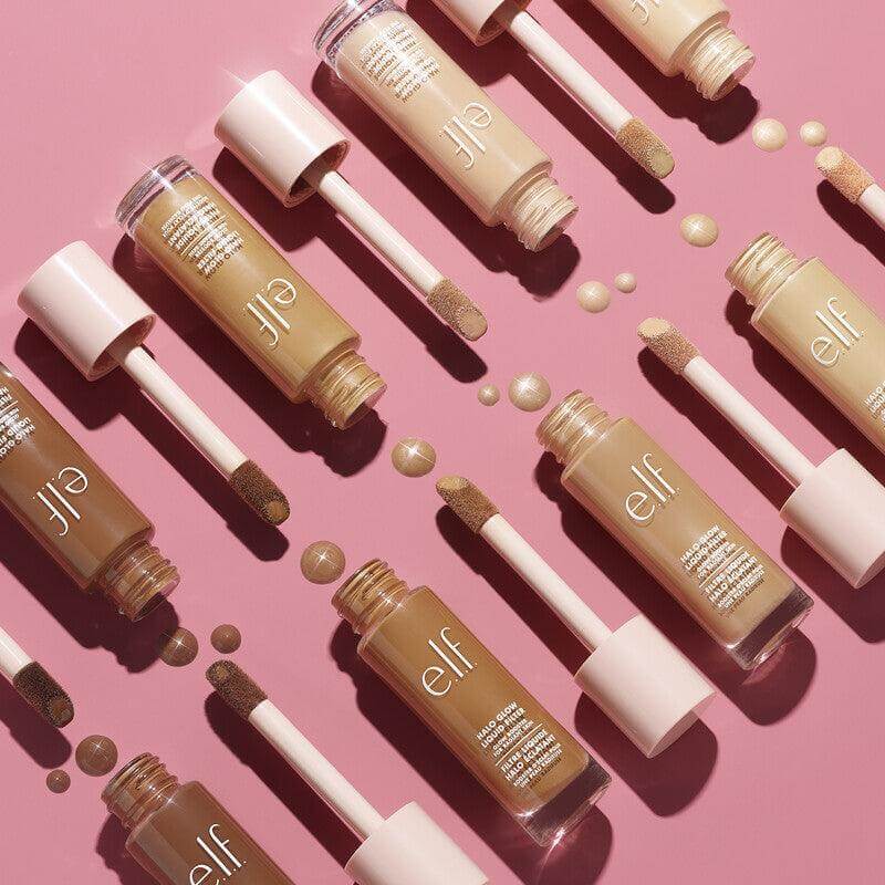 e.l.f Halo Glow Liquid Filter bottles in various shades on a pink background, showcasing hydrating glow booster for all skin tones.