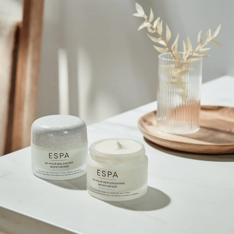 Two ESPA skincare products on a white surface with a blurred background