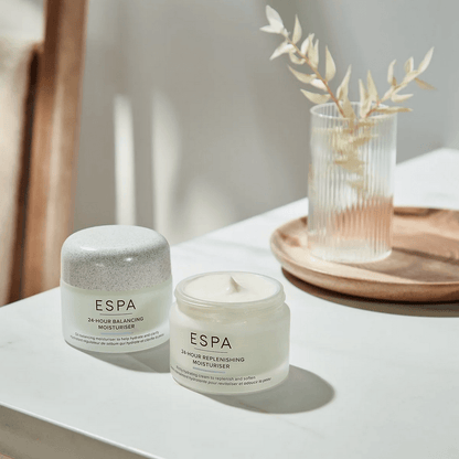 Two ESPA skincare products on a white surface with a blurred background