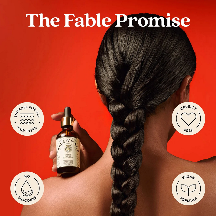 Person with braided hair holding a bottle of 'The Fable & Mane Promise' product against a red background.