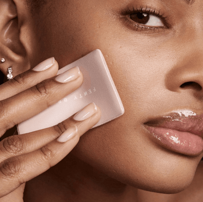Model applying Fenty Beauty Mini Invisimatte Instant Setting Powder for a flawless matte finish.