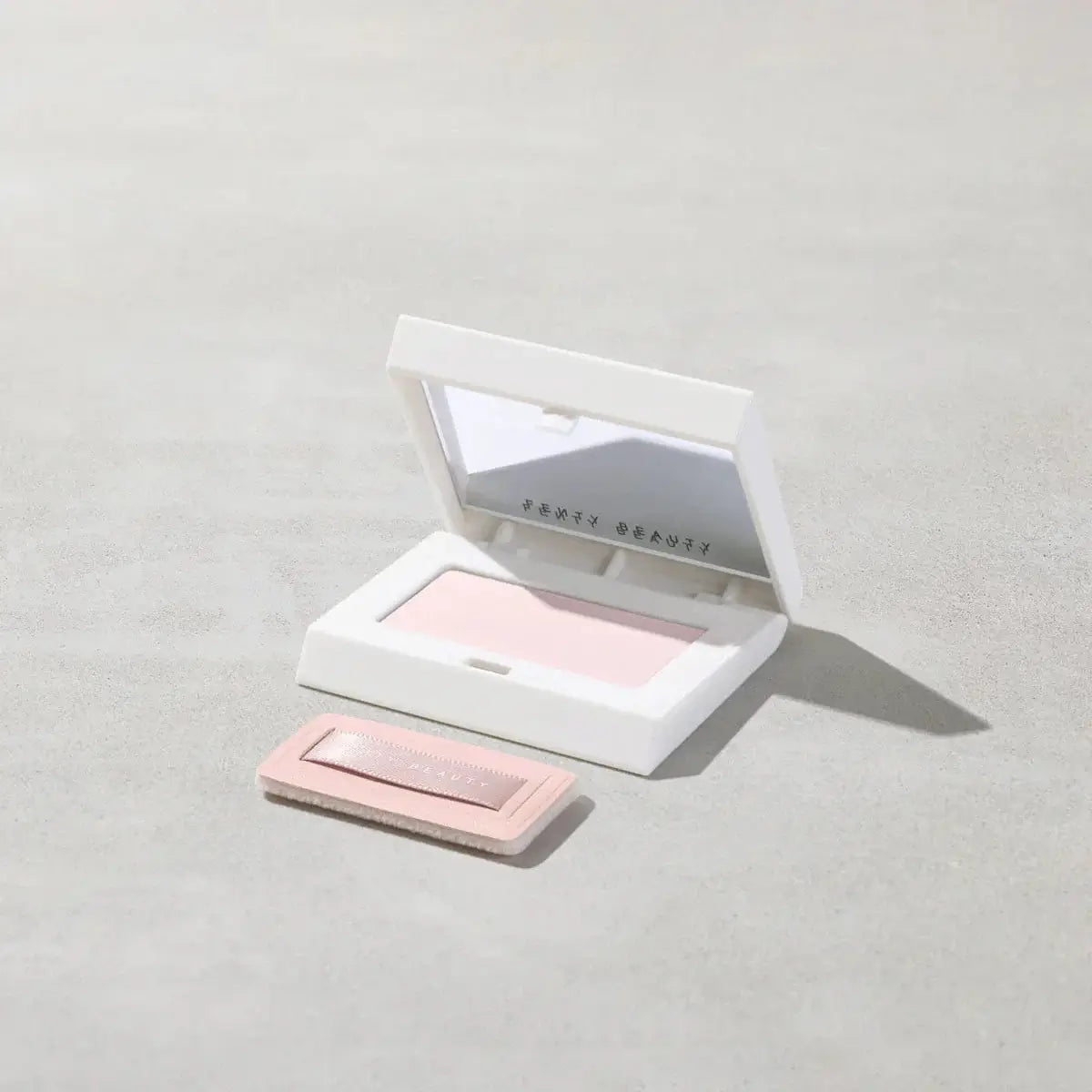 Fenty Beauty Mini Invisimatte Instant Setting + Blotting Powder in sleek white compact, featuring a lightweight, talc-free formula.