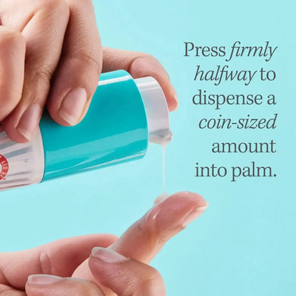 Person dispensing a coin-sized amount of First Aid Beauty serum into palm, demonstrating product use.
