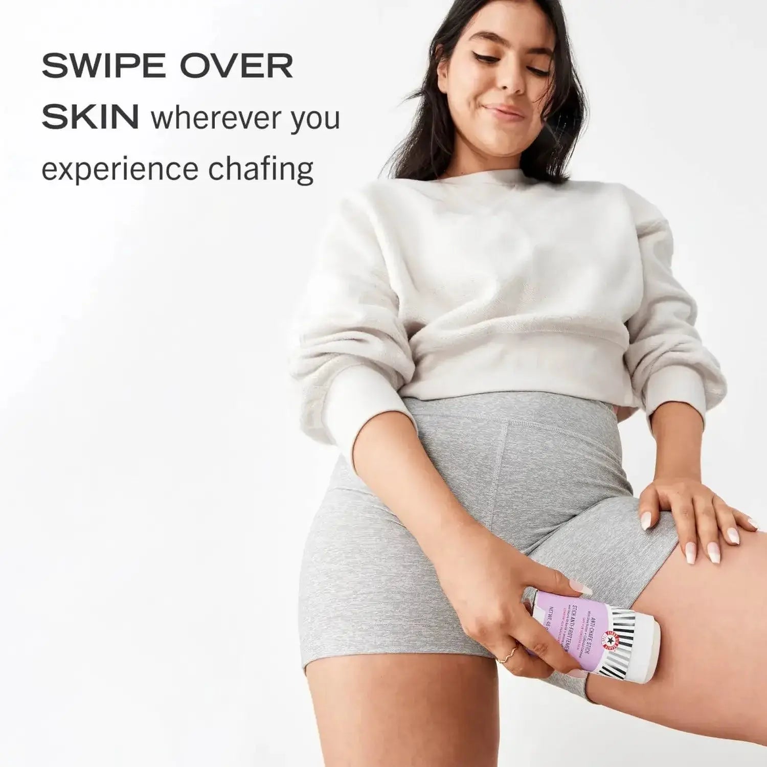 Model demonstrating First Aid Beauty Anti-Chafe Stick on skin to prevent friction and chafing.