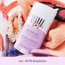 First Aid Beauty Anti-Chafe Stick with shea butter and colloidal oatmeal on a colorful beach background.