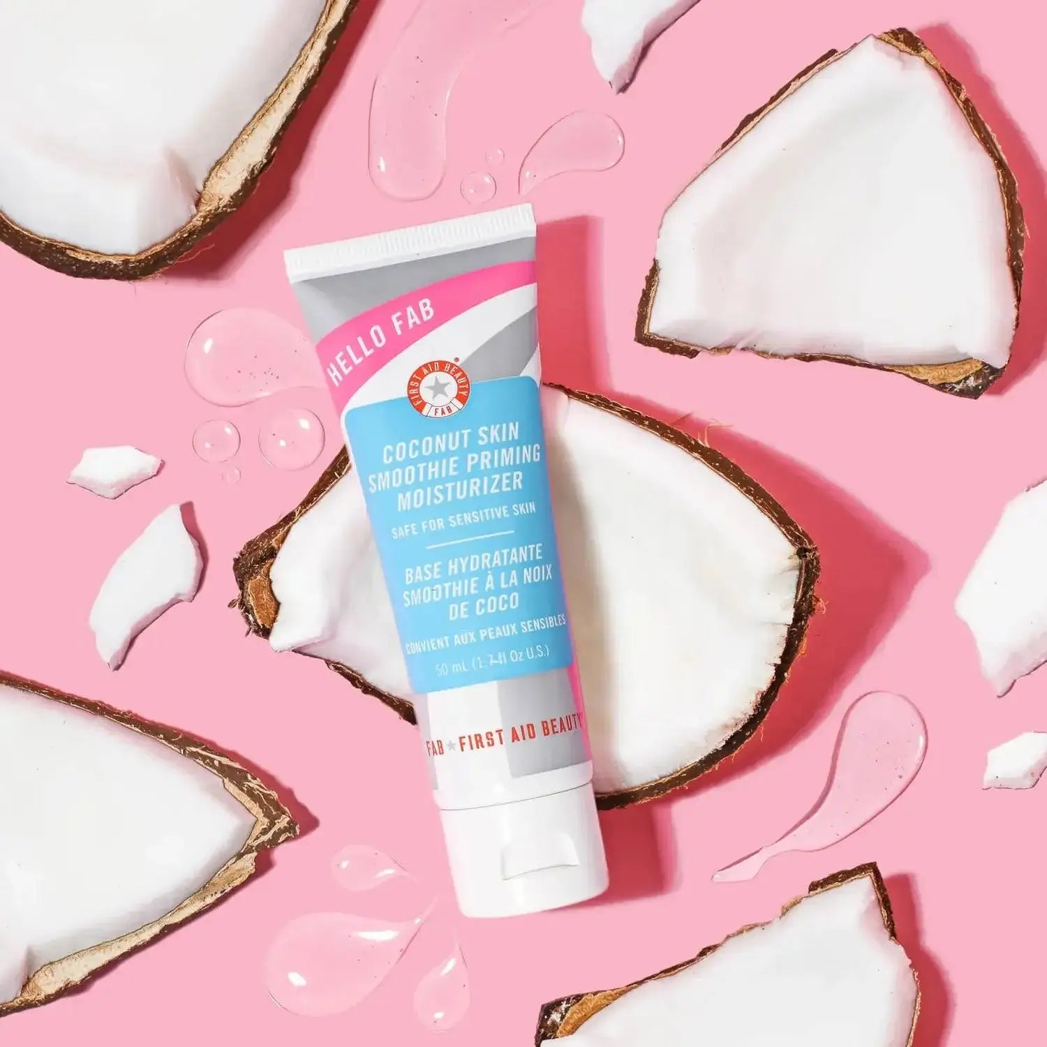 First Aid Beauty Coconut Skin Smoothie Priming Moisturiser 50ml with coconut halves on pink background
