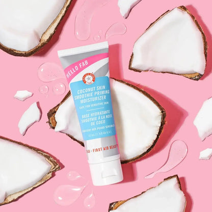 First Aid Beauty Coconut Skin Smoothie Priming Moisturiser 50ml with coconut halves on pink background