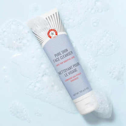 First Aid Beauty Face Cleanser 142g tube, gentle cleanser for sensitive skin, shown with foamy bubbles on a light surface.
