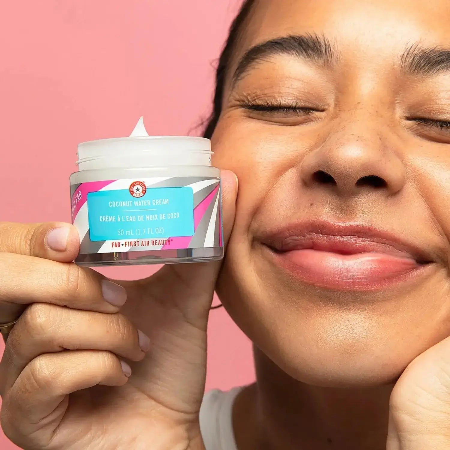 First Aid Beauty Hello Fab Coconut Water Cream in a woman's hand, showcasing its hydrating benefits for the skin.