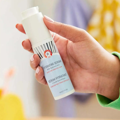 First Aid Beauty Hydrating Serum in hand, featuring hyaluronic acid, for luminous and hydrated skin.
