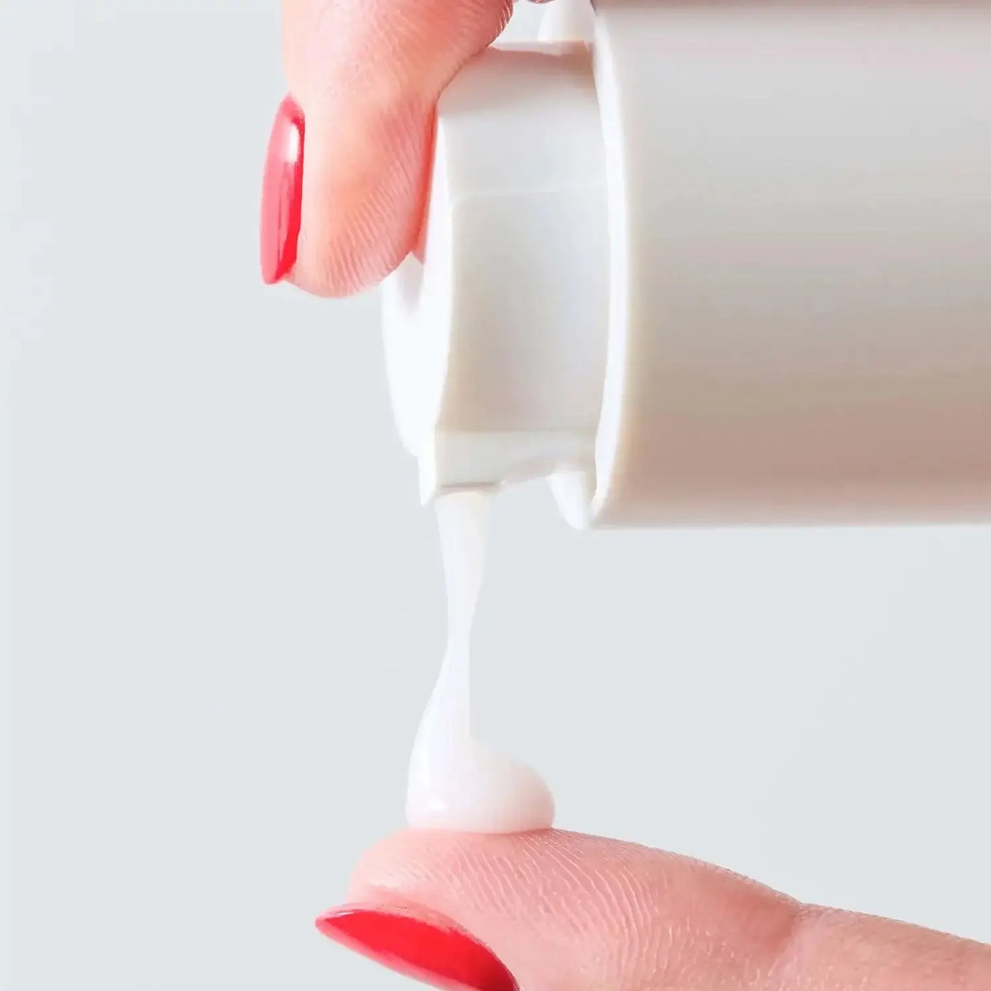 First Aid Beauty Hydrating Serum with Hyaluronic Acid being dispensed onto a fingertip, showcasing its creamy texture.