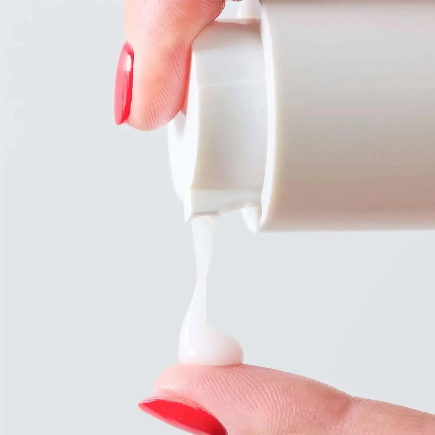 First Aid Beauty Hydrating Serum with Hyaluronic Acid being dispensed onto a fingertip, showcasing its creamy texture.