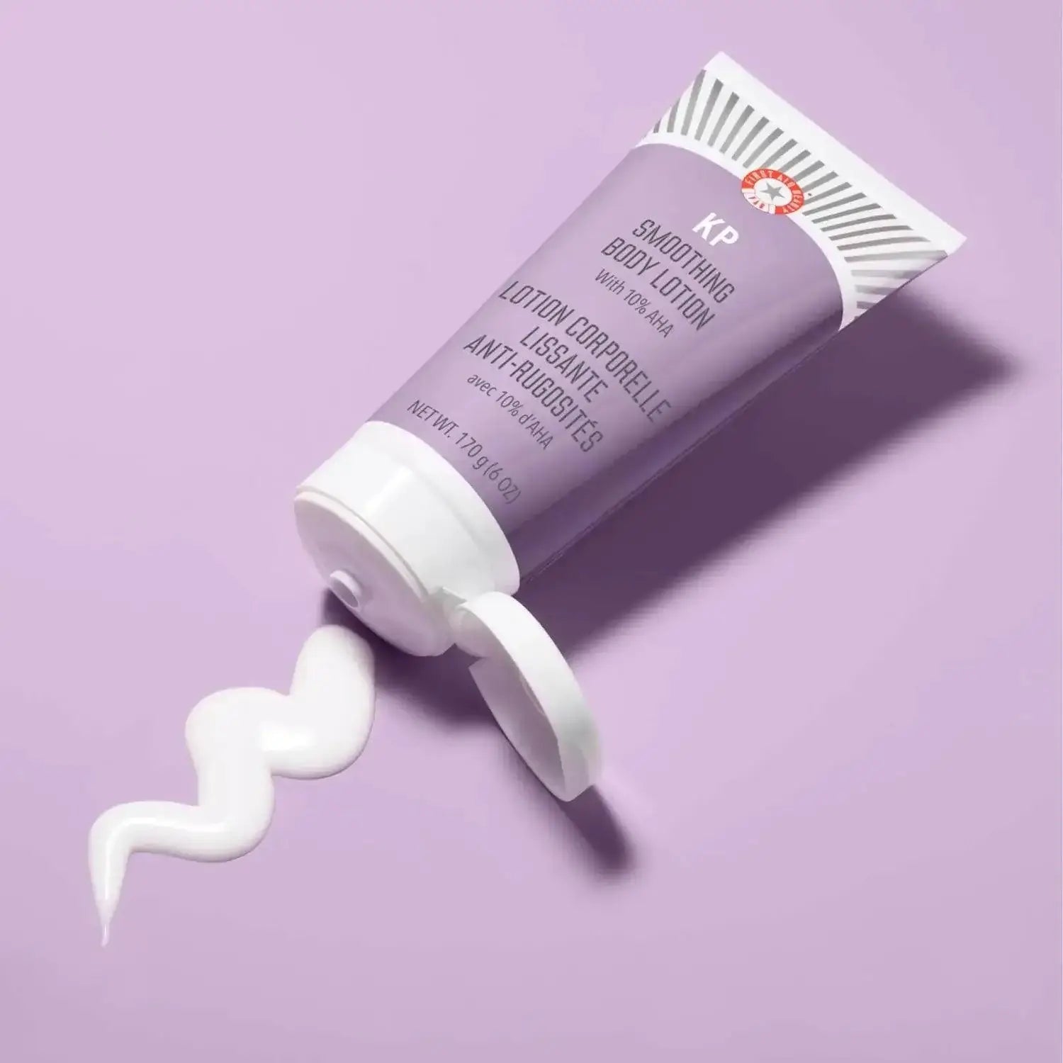 First Aid Beauty KP Smoothing Body Lotion with 10% AHA in a purple tube, showcasing smooth white lotion.