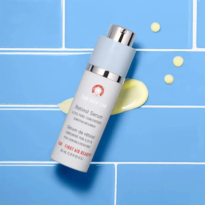 First Aid Beauty Skin Lab Retinol Serum 0.25% Pure Concentrate in a 30ml bottle on a blue background.