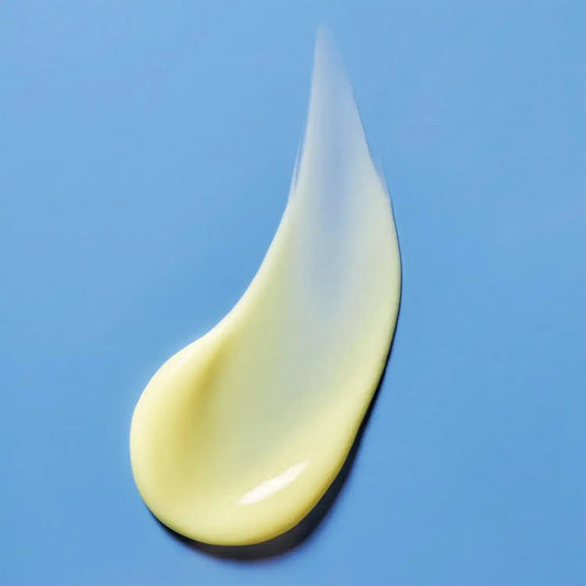 Smooth, creamy texture of First Aid Beauty Skin Lab Retinol Serum on a blue background.