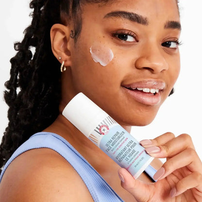 Woman applying First Aid Beauty Ultra Repair Face Moisturizer 50ml for instant hydration and soft skin.
