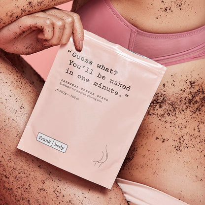 Person holding a coffee scrub packet with text and 'Trunk Body' branding.