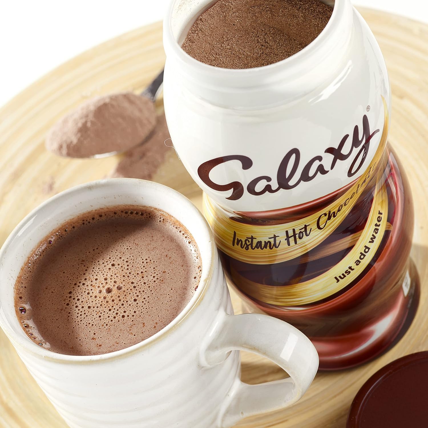 Galaxy instant hot chocolate jar with a cup of hot chocolate on a wooden surface
