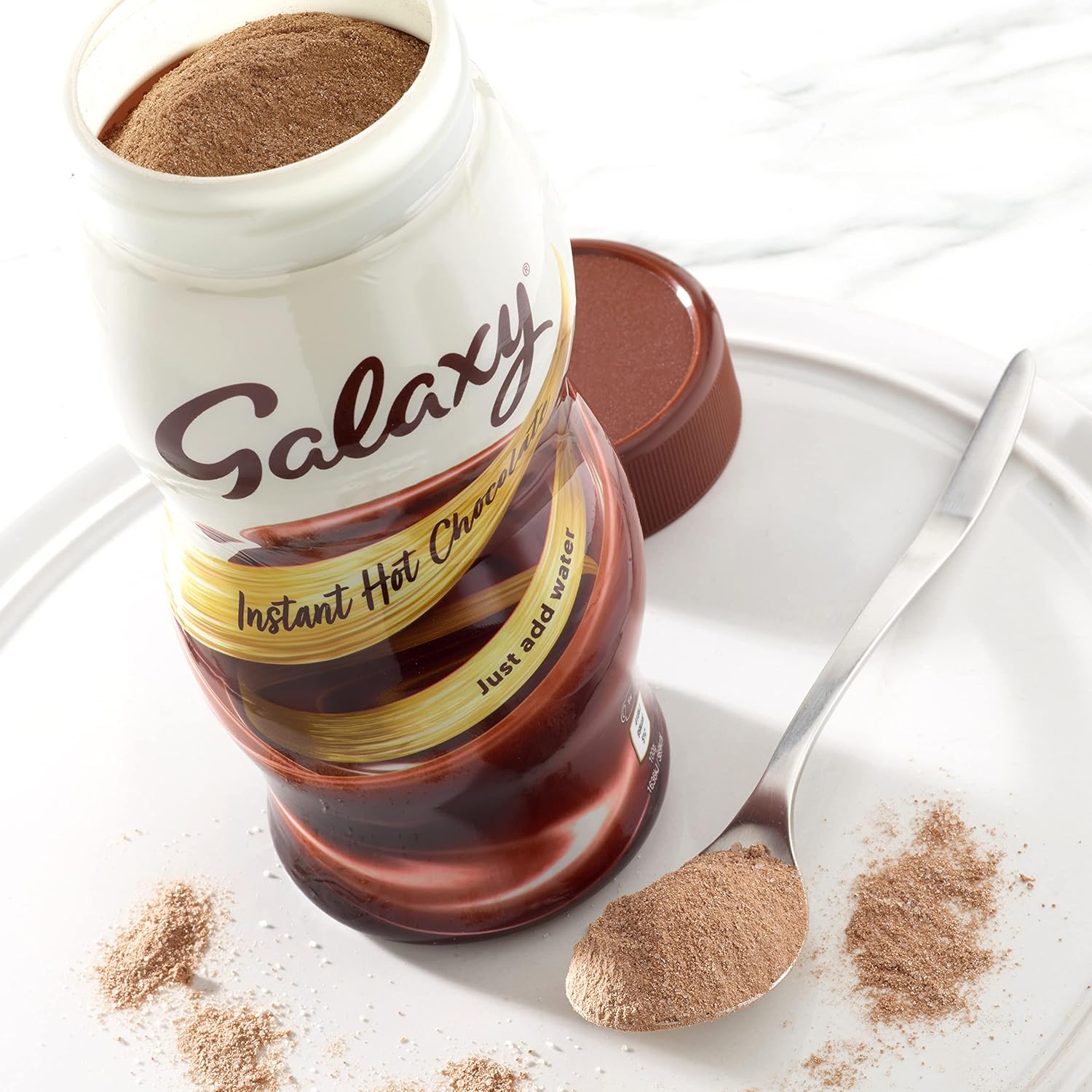 Galaxy Instant Hot Chocolate with a spoonful of powder on a white plate